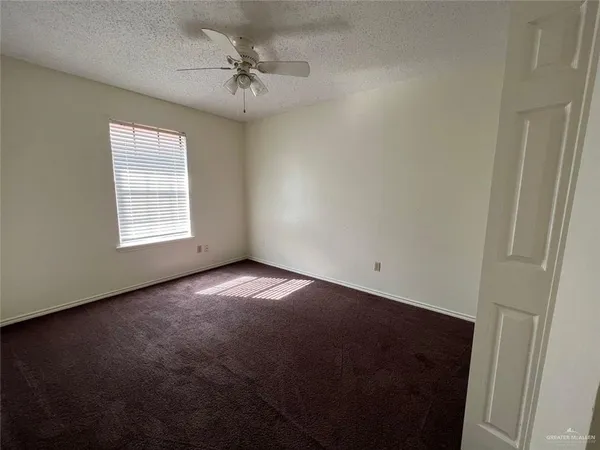 an empty room with windows and fan