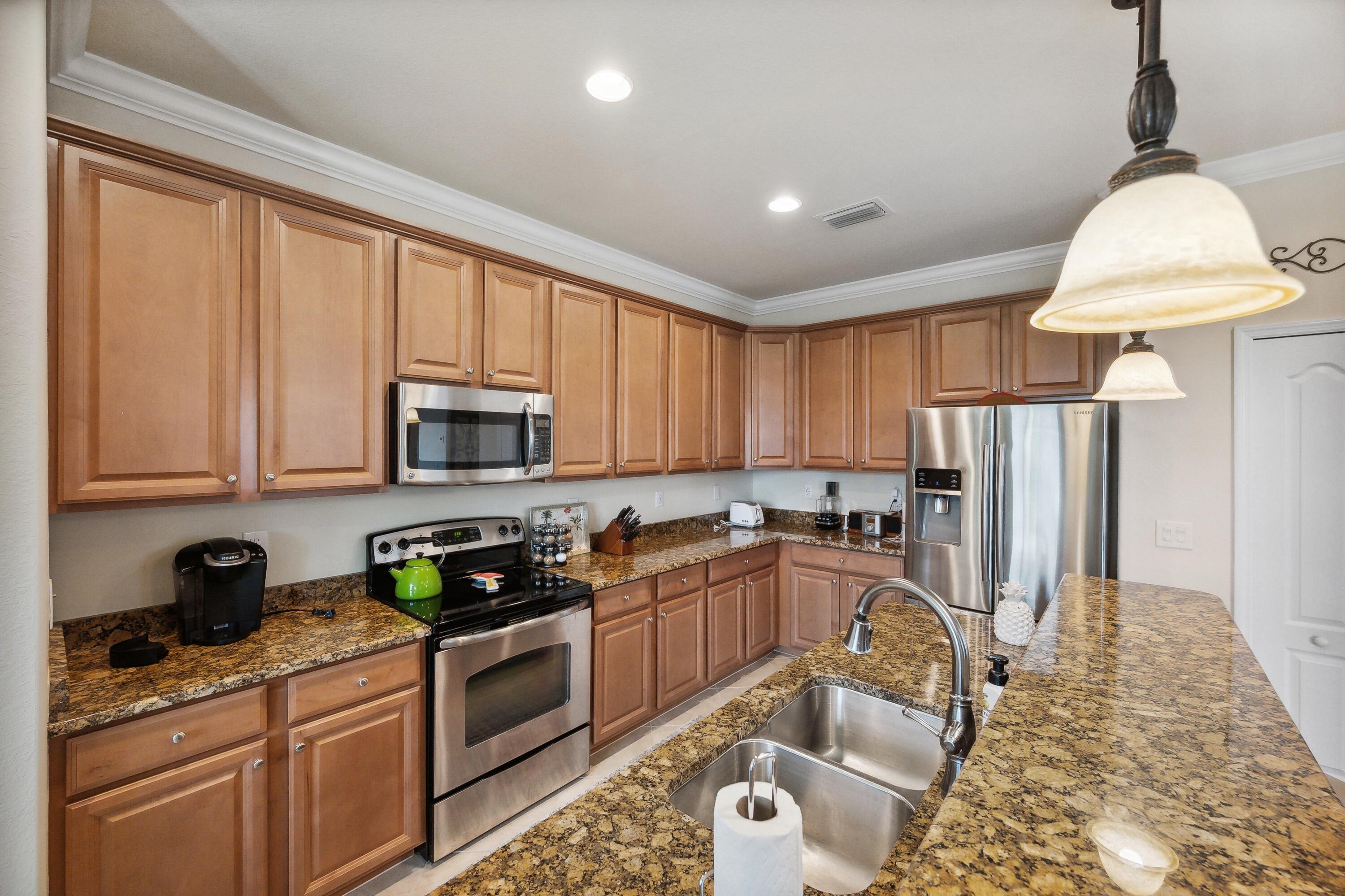 3833 Ruby Way Naples, FL 34114 - Photo 13 of 31 a kitchen with granite countertop a refrigerator stove top oven a sink and dishwasher