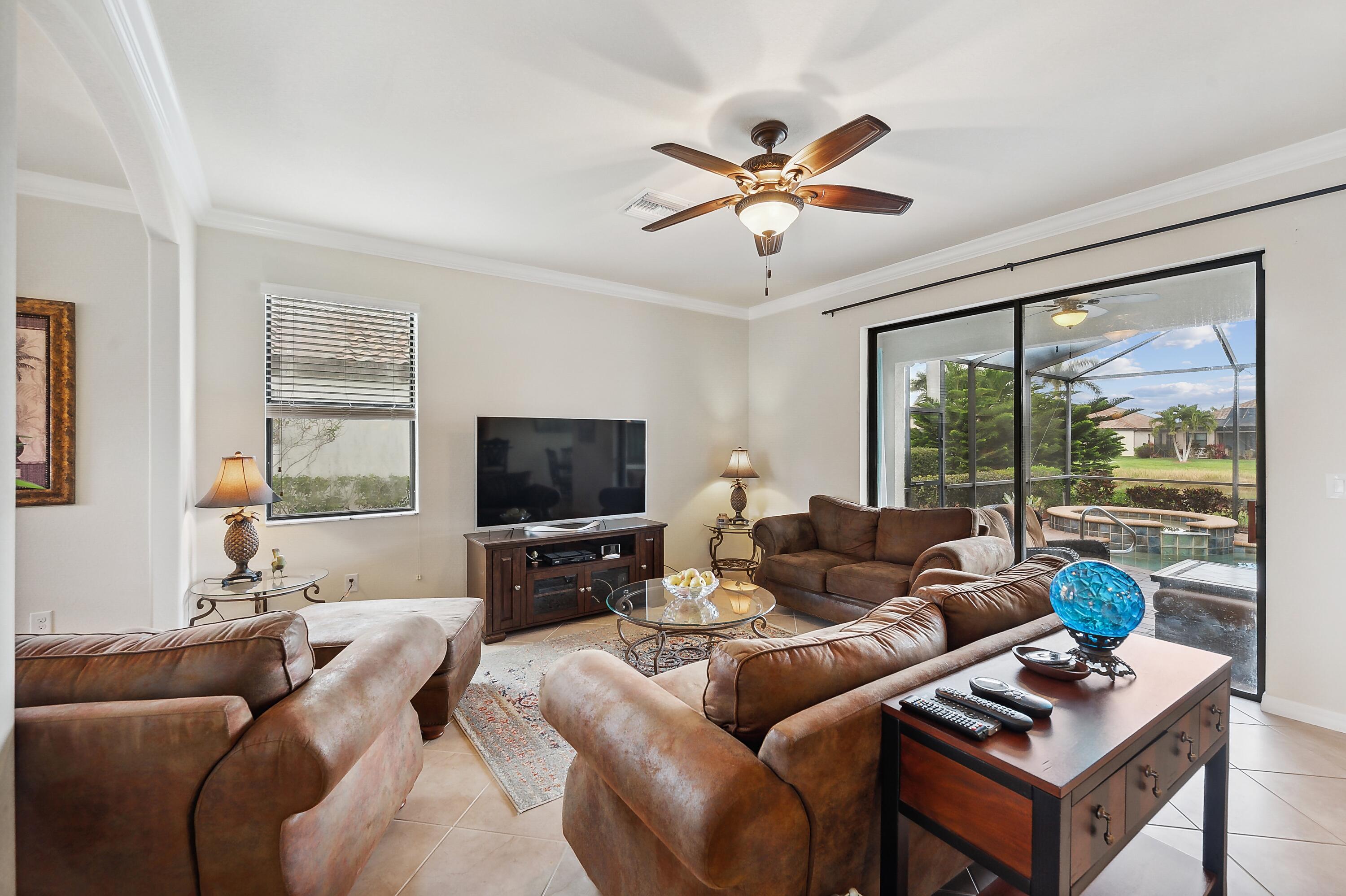 3833 Ruby Way Naples, FL 34114 - Photo 6 of 31 a living room with furniture a flat screen tv and a large window