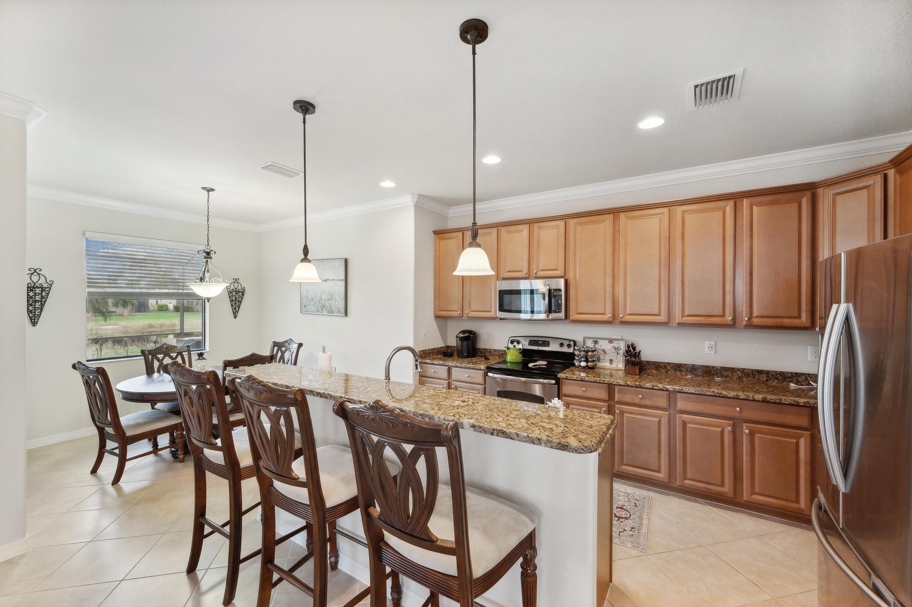 3833 Ruby Way Naples, FL 34114 - Photo 10 of 31 a kitchen with a dining table chairs sink and cabinets