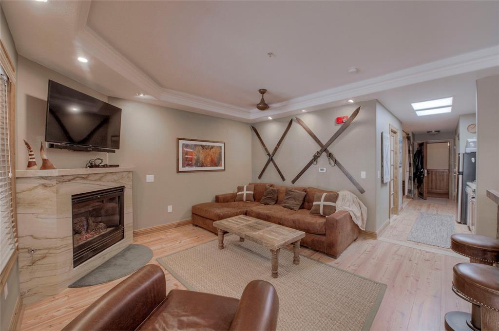 655 4 O Clock Road, Unit 108 Breckenridge, CO 80424 - Photo 3 of 20 a living room with furniture a flat screen tv and a fireplace