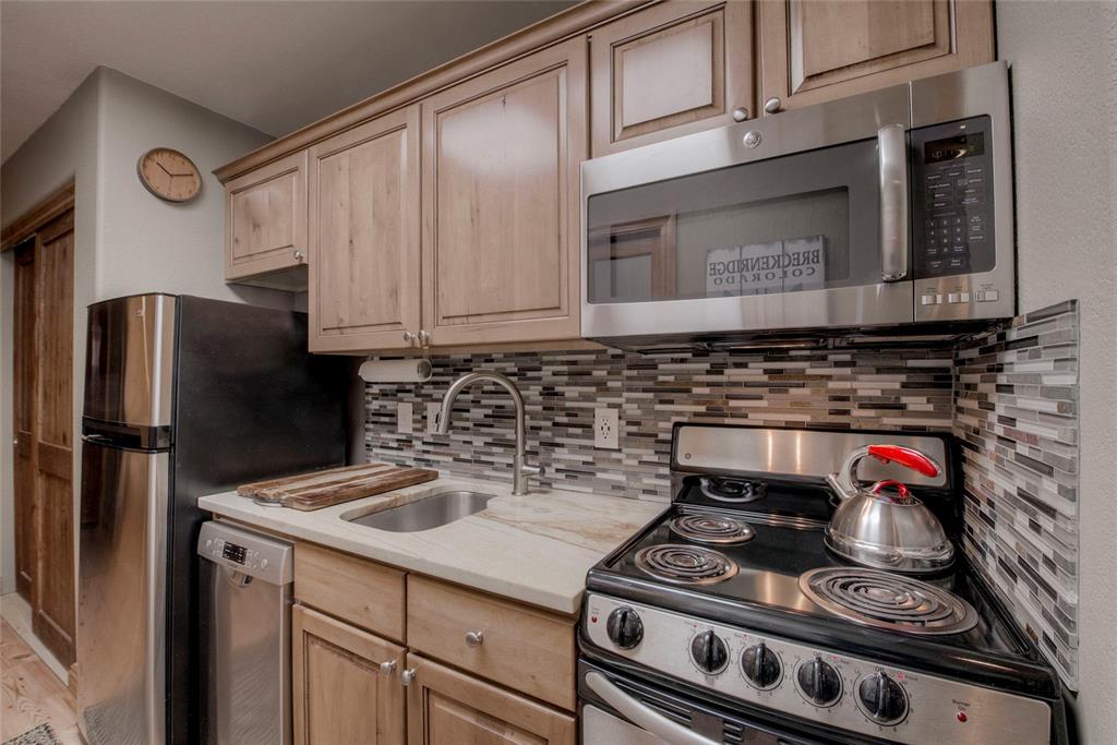 655 4 O Clock Road, Unit 108 Breckenridge, CO 80424 - Photo 9 of 20 a kitchen with stainless steel appliances granite countertop a stove and a refrigerator