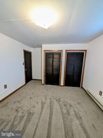 a view of an empty room with closet and utility room