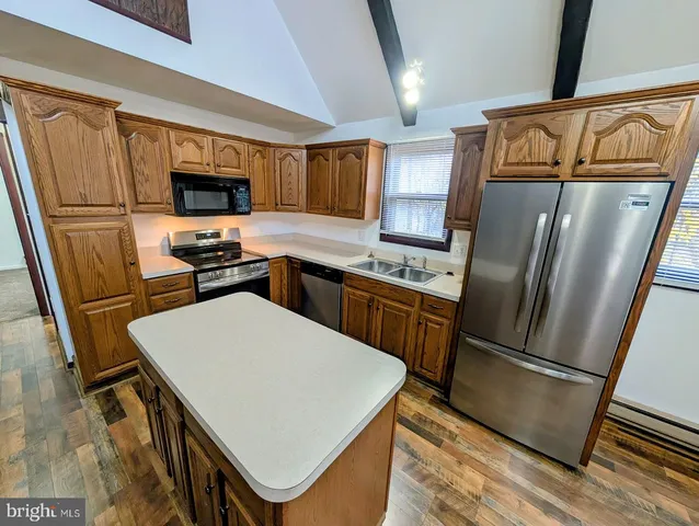 a kitchen with stainless steel appliances a refrigerator stove microwave and sink