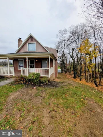 a view of a white house with a yard and tree