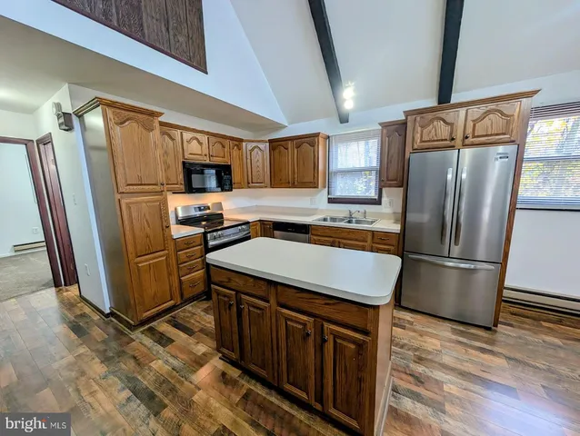 a kitchen with stainless steel appliances a refrigerator and a stove top oven