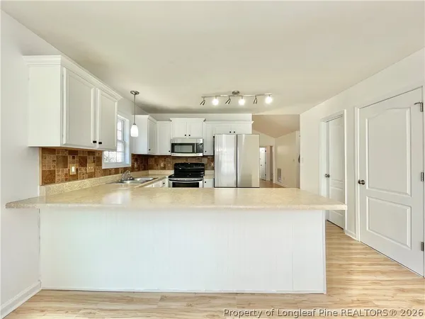 a large white kitchen with stainless steel appliances
