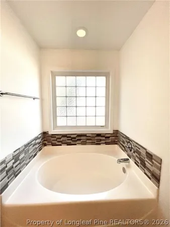 a bathroom with a bathtub and window