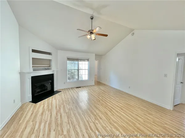 an empty room with windows and a fireplace