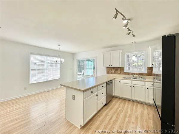 a kitchen with granite countertop cabinets stainless steel appliances a sink and a window