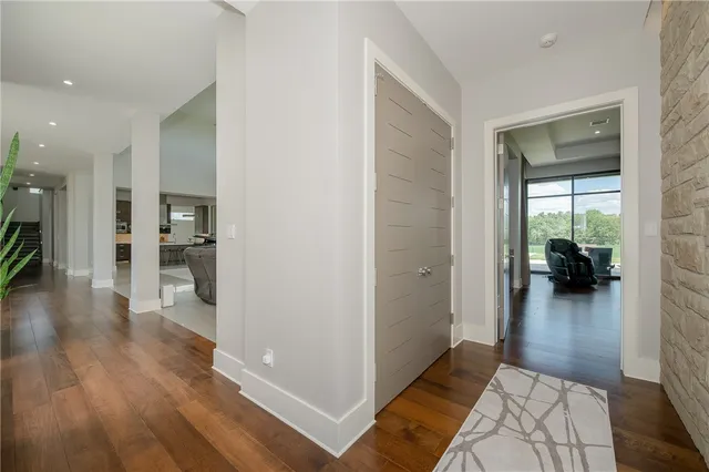 a view of a hallway view with wooden floor and a living room