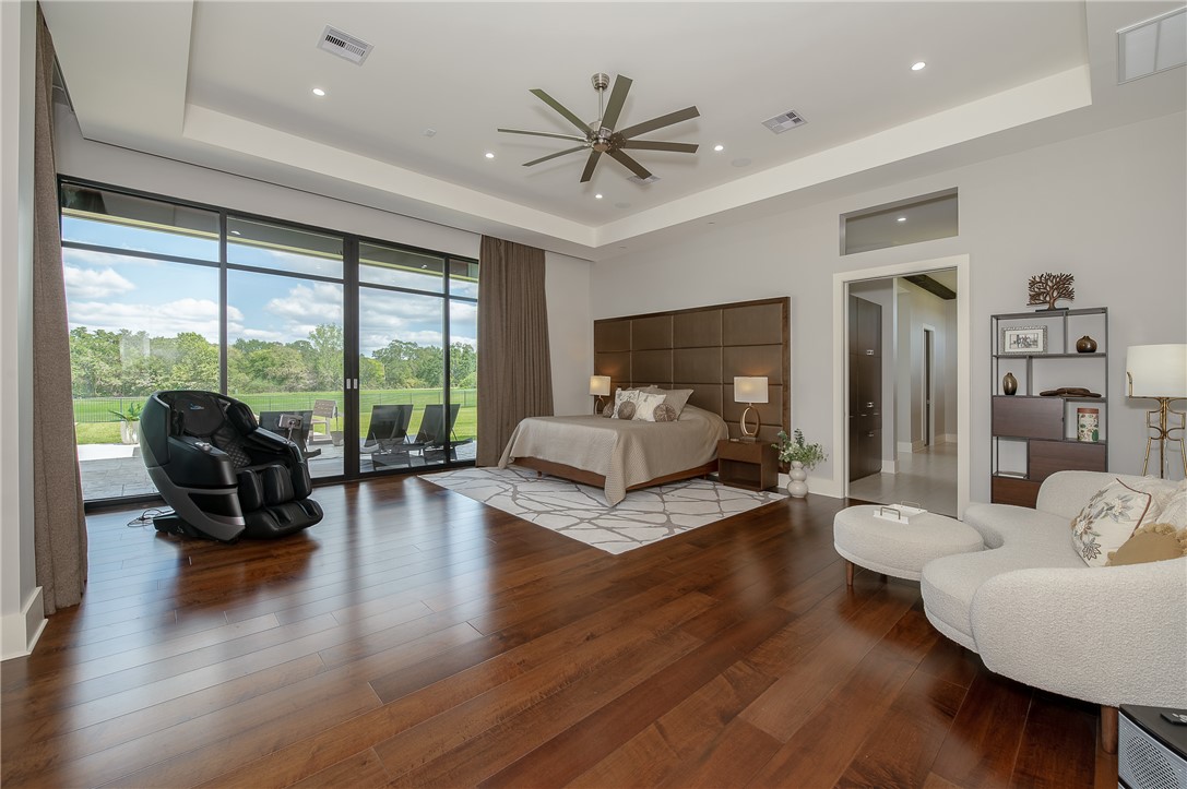 3320 Sycamore Trail Bryan, TX 77807 - Photo 22 of 49 Bedroom with a tray ceiling, access to exterior, visible vents, and wood finished floors