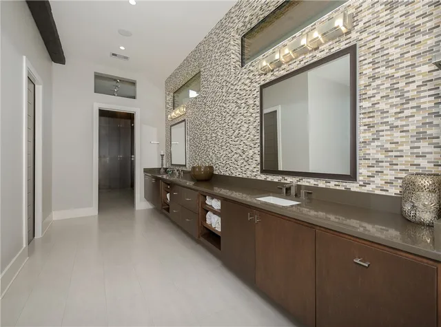 a bathroom with double vanity sinks and a large mirror