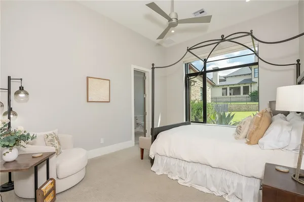a bedroom with a bed a chandelier and dresser