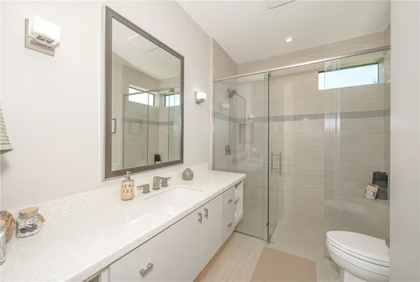 a spacious bathroom with a double vanity sink toilet and shower