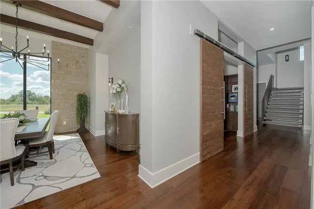 a view of a hallway with wooden floor and stairs