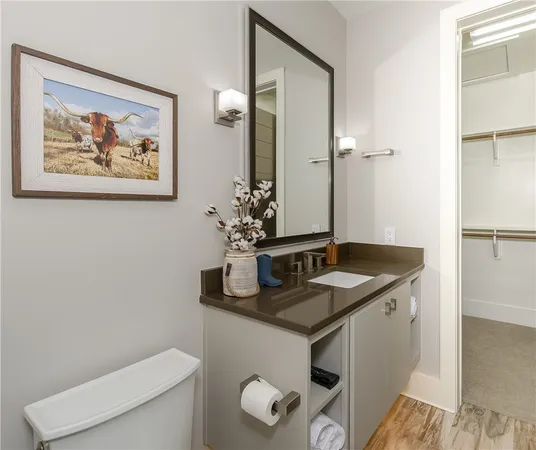 a bathroom with a granite countertop sink a toilet and mirror