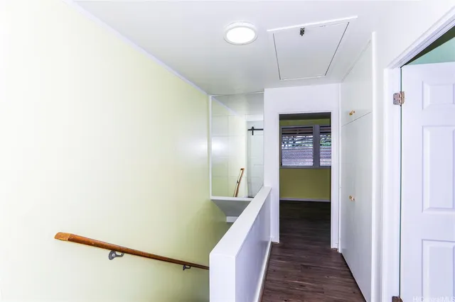 a view of a hallway with wooden floor and staircase