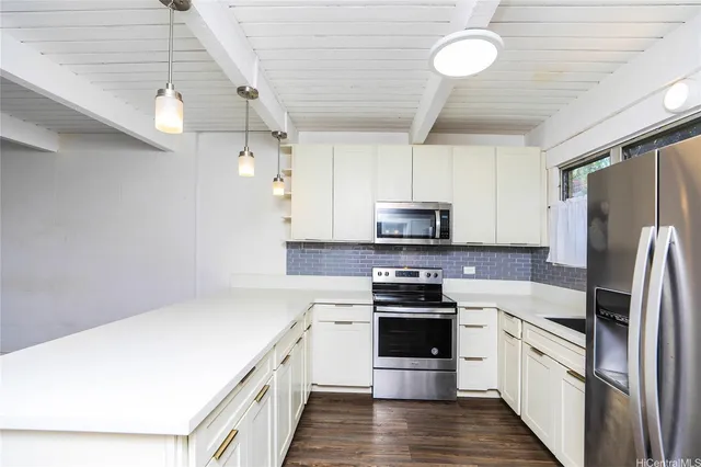 a kitchen with stainless steel appliances a refrigerator a stove a sink dishwasher a oven with white cabinets and wooden floor