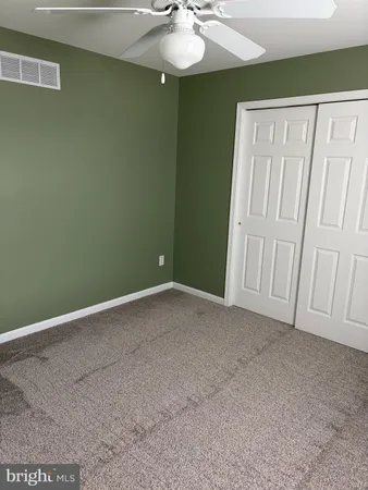 a view of an empty room with a chandelier fan