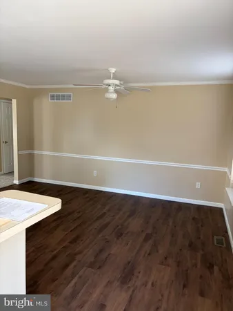 a view of a room with an empty space and a ceiling fan