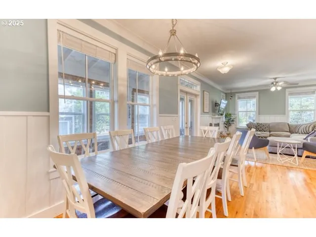 a dining room with wooden floor a chandelier a wooden table and chairs