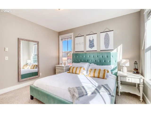 a bedroom with a bed a table and painting on the wall