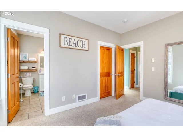 a view of a room with wooden floor and a bathroom