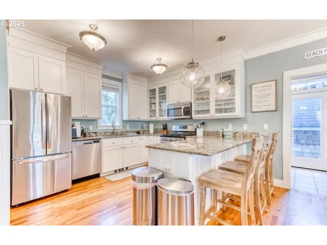 a kitchen with stainless steel appliances granite countertop a refrigerator and a stove top oven