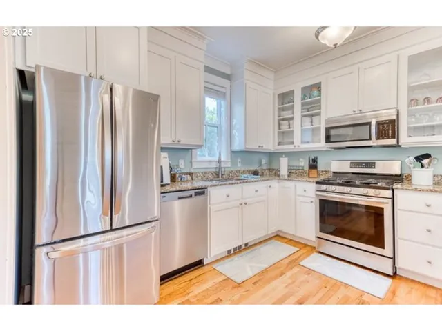 a kitchen with stainless steel appliances a refrigerator sink and cabinets