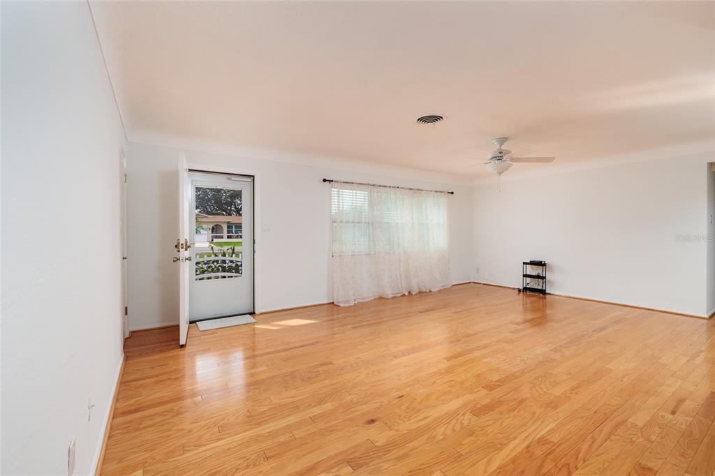 13877 94th Avenue North Seminole, FL 33776 - Photo 12 of 44 a view of an empty room with window and wooden floor