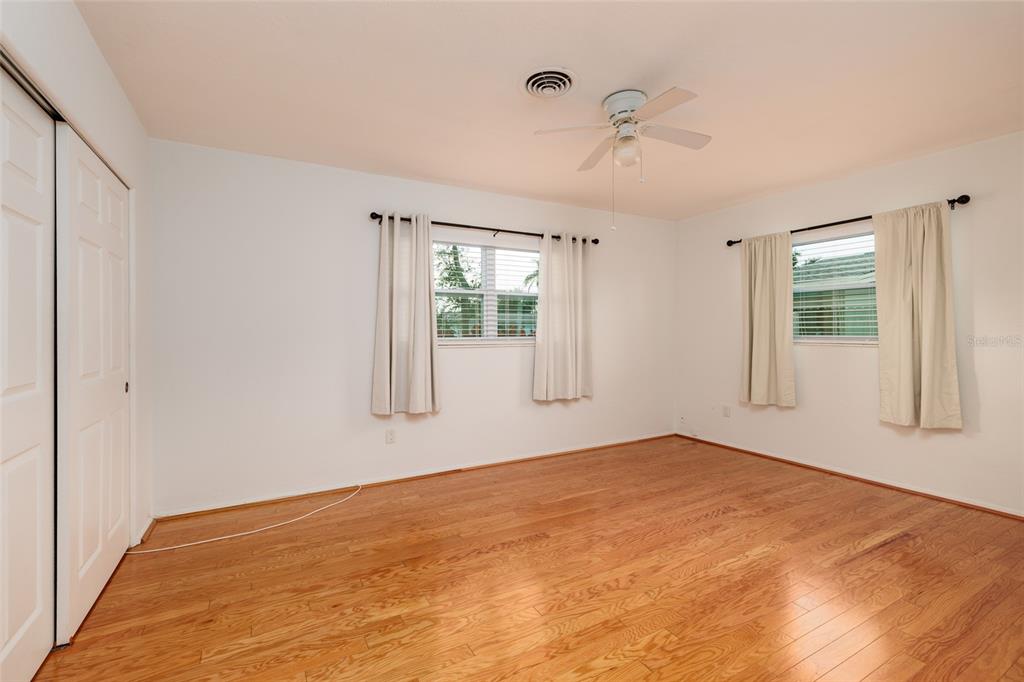 13877 94th Avenue North Seminole, FL 33776 - Photo 15 of 44 a view of empty room with wooden floor and fan