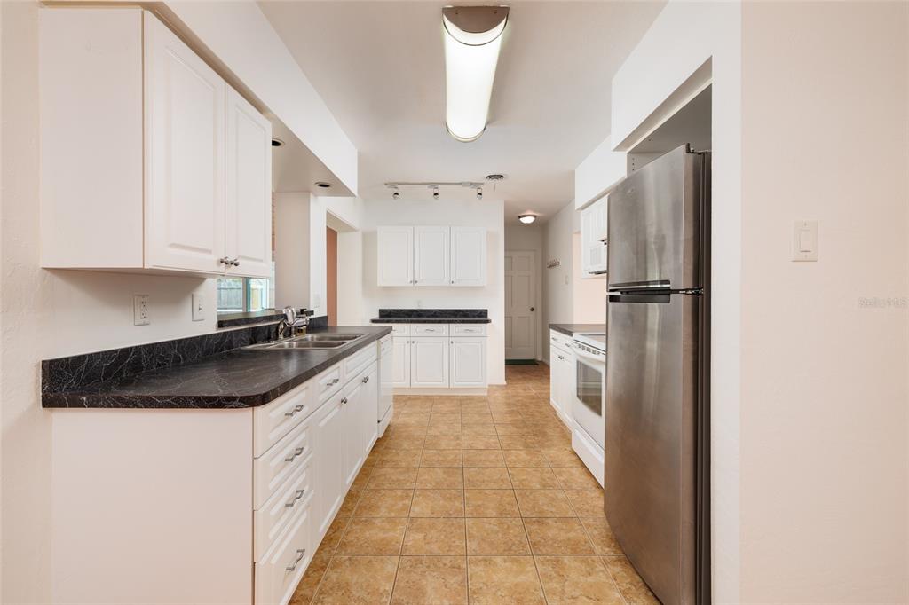 13877 94th Avenue North Seminole, FL 33776 - Photo 9 of 44 a large kitchen with a sink and refrigerator