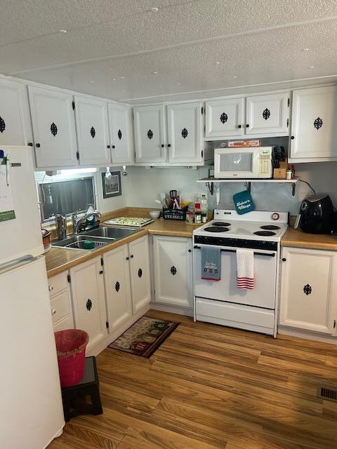 143 Southeast Easy Street Stuart, FL 34994 - Photo 2 of 12 a kitchen with white cabinets stainless steel appliances and wooden floor