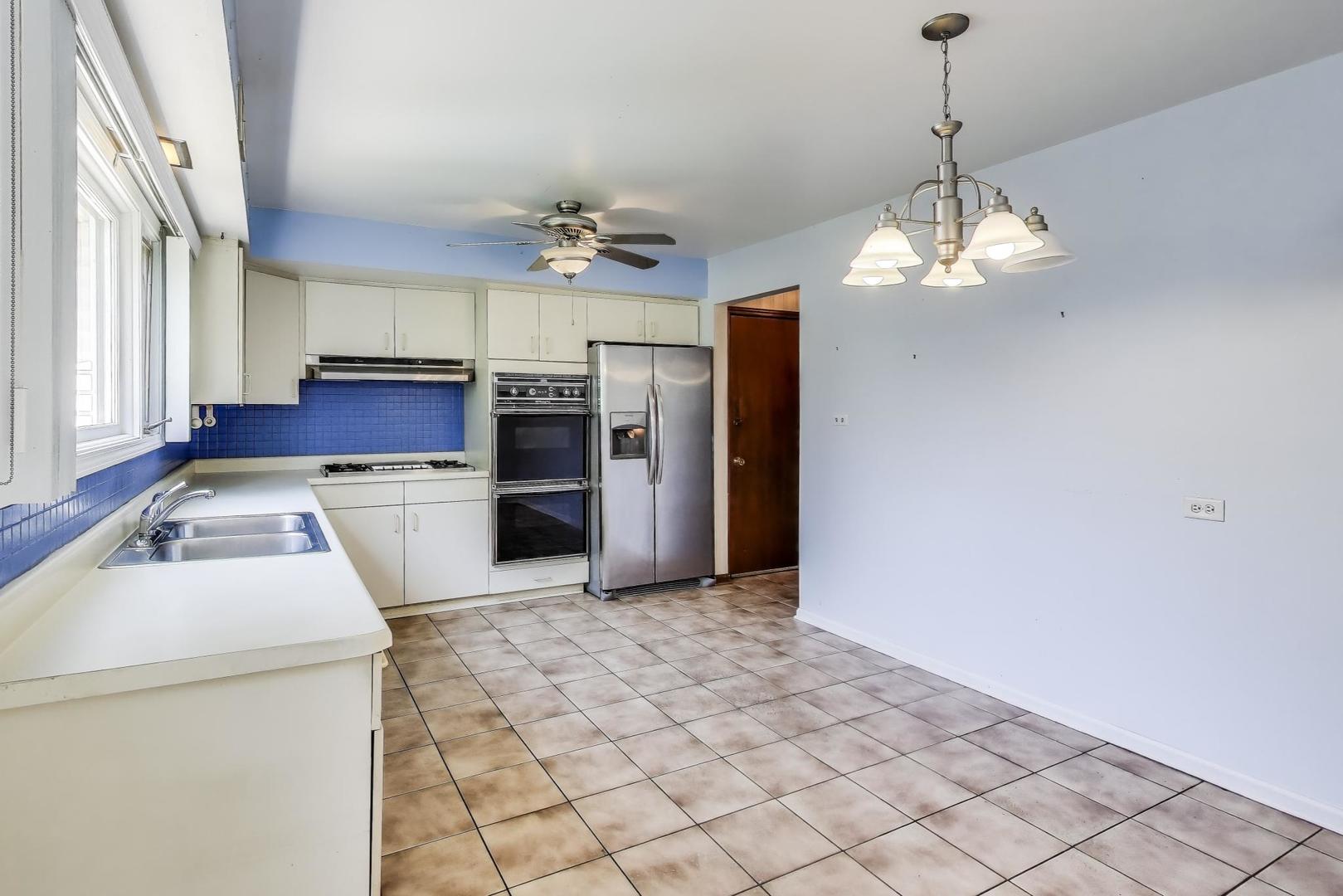 3509 Lawson Road Glenview, IL 60026 - Photo 6 of 54 a kitchen with stainless steel appliances granite countertop a refrigerator a sink dishwasher a stove and a dining table with wooden floor