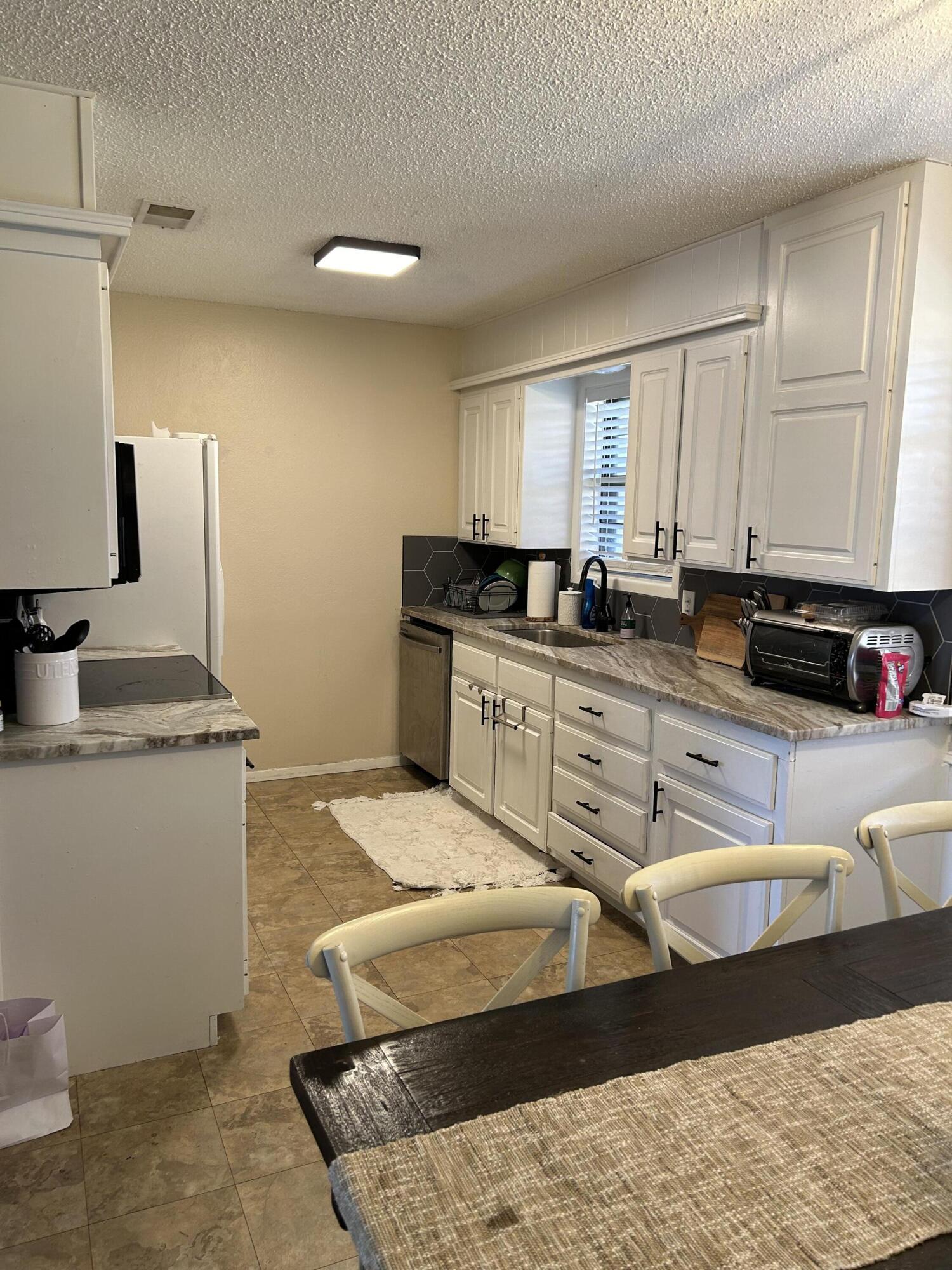 4809 8th Street Lubbock, TX 79416 - Photo 4 of 14 a kitchen with stainless steel appliances granite countertop a sink stove and cabinets