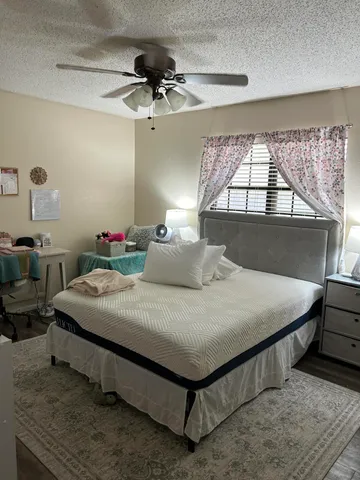 a bedroom with a bed a chandelier and a window
