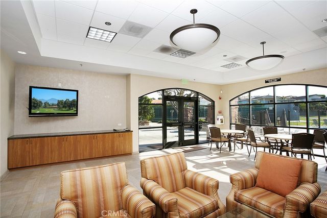 a living room with furniture a chandelier and a large window