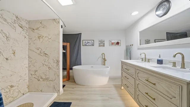 a spacious bathroom with double vanity a toilet a mirror and shower