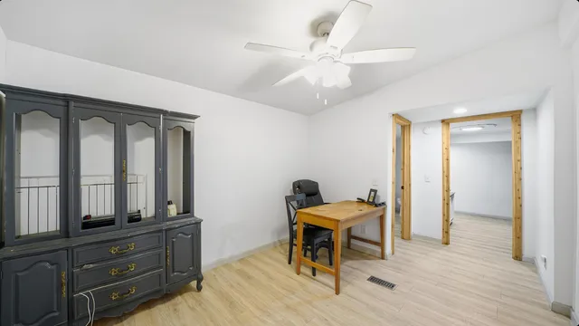 a view of a workspace with furniture and a window