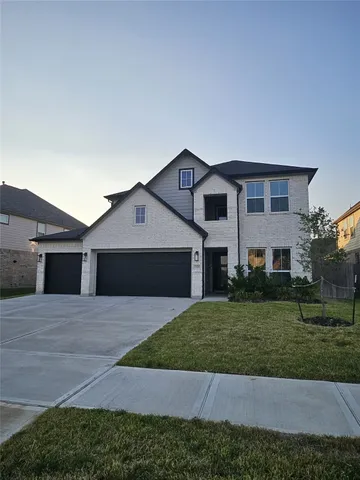 a front view of house with yard and trees in the background