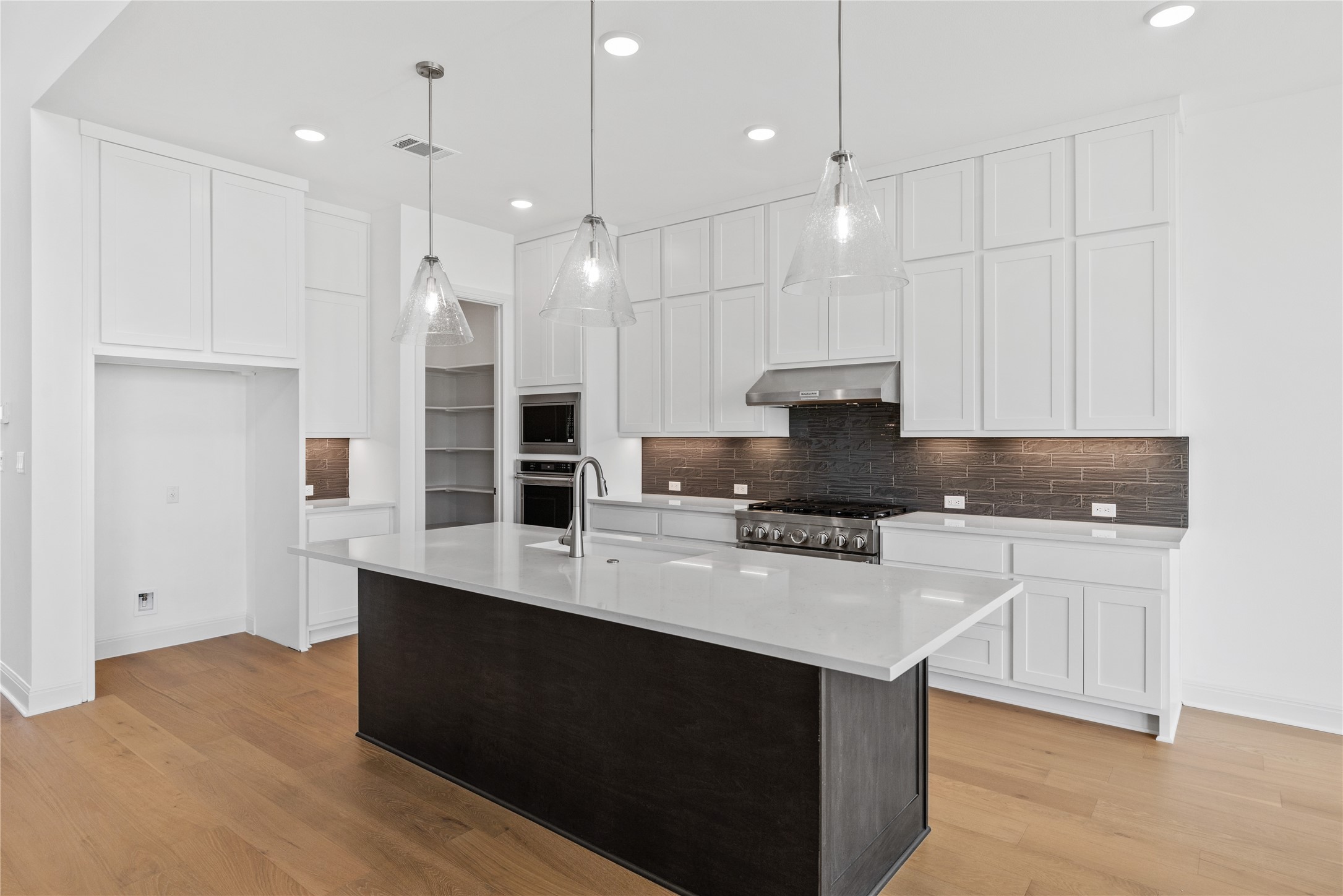 905 South Hemingway Loop Liberty Hill, TX 78642 - Photo 11 of 35 a kitchen with kitchen island a sink stainless steel appliances and cabinets