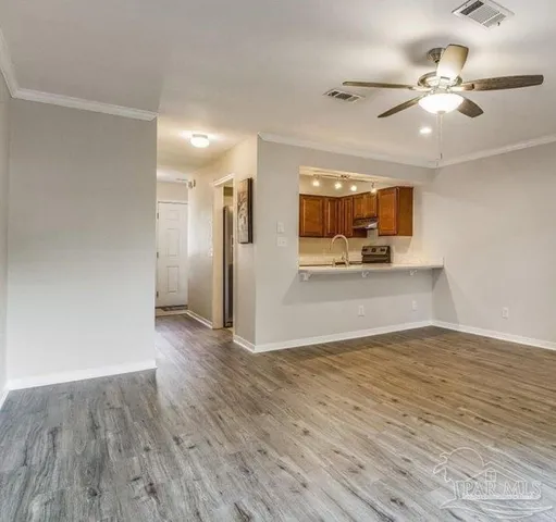 a view of a livingroom with a kitchen counter tops and wooden floor