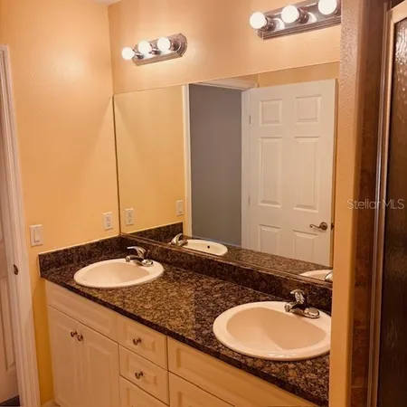 a bathroom with a granite countertop sink and a mirror