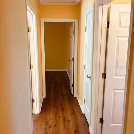 a view of a hallway with wooden floor and staircase