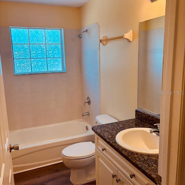 925 East Rembrandt Way, Unit 104 Inverness, FL 34453 - Photo 28 of 36 a bathroom with a granite countertop sink a toilet and bathtub