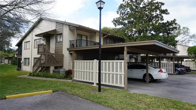 a view of a house with a small yard and wooden fence
