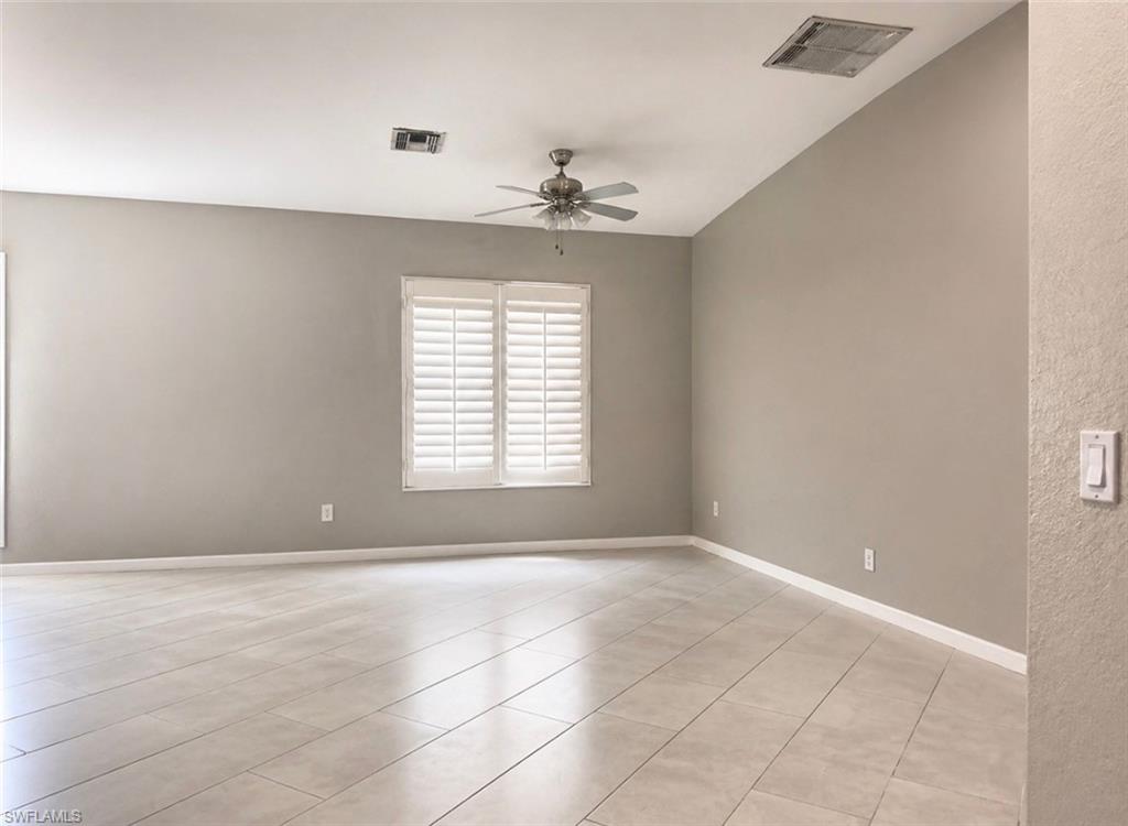2541 55th Terrace Southwest Naples, FL 34116 - Photo 3 of 6 an empty room with windows and chandelier fan