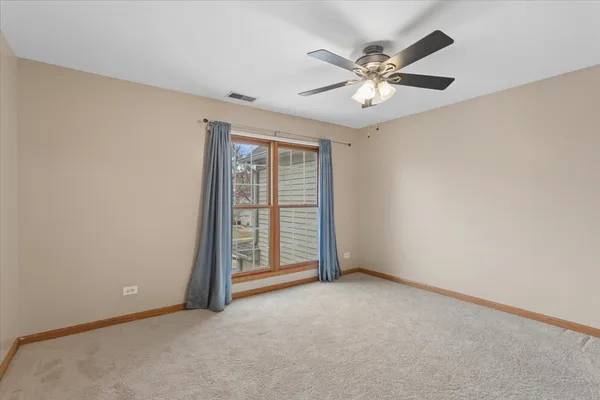 an empty room with closet and fan