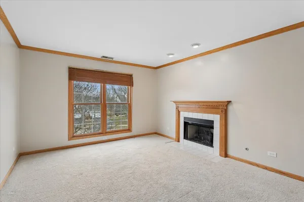 a view of an empty room with a fireplace and a window